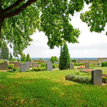 Blick auf Erdbestattungsgräber auf dem grünen Friedhof in Warmsen