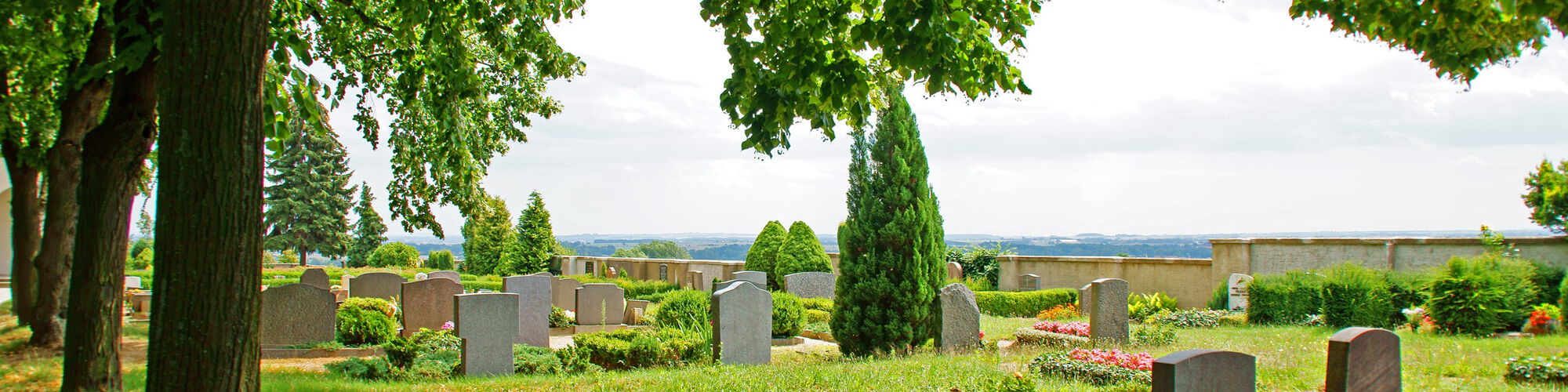 Blick auf Erdbestattungsgräber auf dem grünen Friedhof in Warmsen